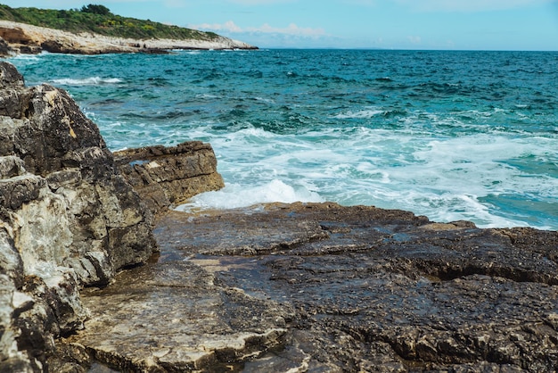 Vue sur l'eau avec des vagues avec espace de copie de falaise rocheuse