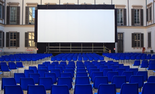 Vue de l'écran et des chaises bleues vides pour le cinéma en plein air