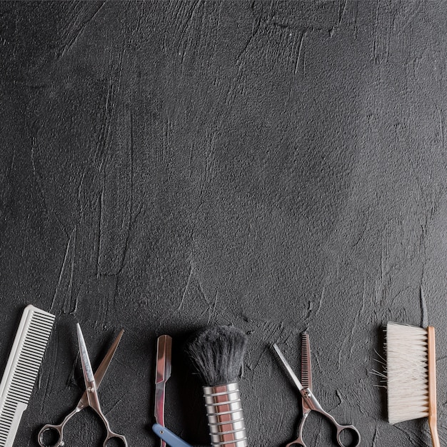 Photo vue élevée de divers outils de coiffeur sur fond noir