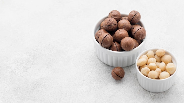 Photo vue élevée des noix de macadamia et du chocolat dans des bols