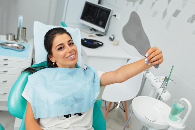 Vue d'ensemble de la prévention des caries dentaires.Femme à la chaise du dentiste lors d'une procédure dentaire Belle femme sourire se bouchent. Sourire sain. Beau sourire féminin.