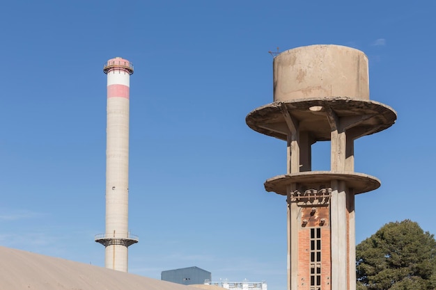 Vue d'un entrepôt abandonné élevé au-dessus d'une tourelle et en arrière-plan une grande cheminée industrielle Sagunto Valence Espagne