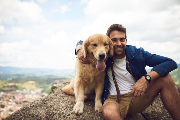 La vue est superbe d'ici Portrait recadré d'un beau jeune homme et de son chien faisant une pause lors d'une randonnée dans les montagnes