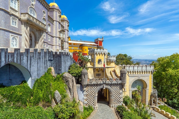 Vue extérieure et large du coloré palais de Pena avec le chemin menant à l'entrée en arche