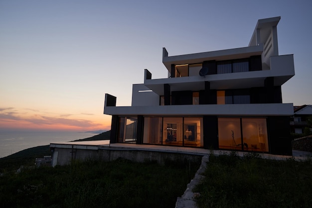 Vue extérieure d'une villa moderne de maison contemporaine au coucher du soleil