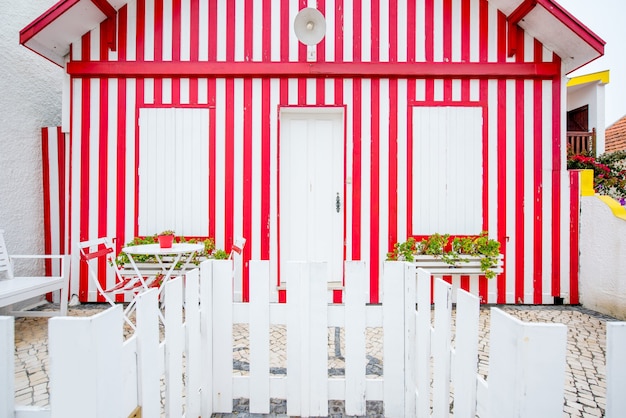 Vue de façade sur la belle maison rayée colorée avec des fenêtres et une porte pour le fond