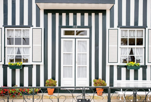 Vue de façade sur la belle maison rayée colorée avec des fenêtres et une porte pour le fond