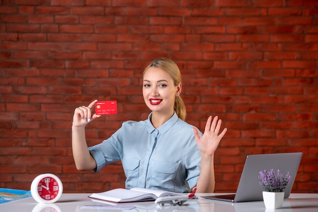 vue de face de l'agent de voyage tenant la carte de l'assistant de carte de crédit rouge gestionnaire mondial de l'argent travail professionnel emploi