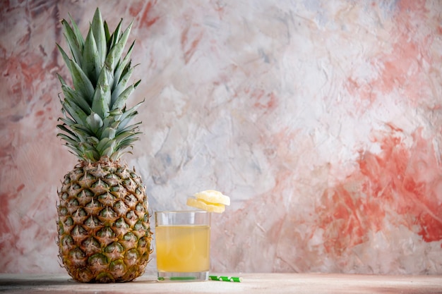 vue de face ananas frais anneaux d'ananas secs sur pipette en verre de jus sur fond beige avec place pour copie