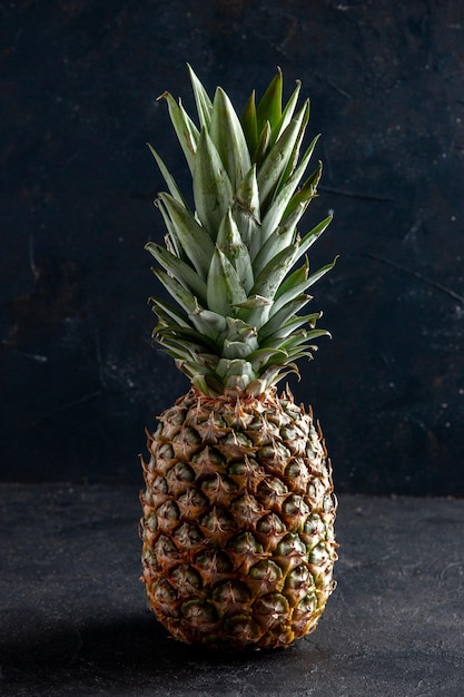 vue de face ananas fruit sur fond sombre