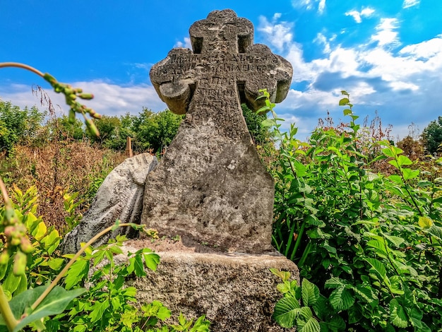 Vue de face de l'ancienne croix de pierre dans un cimetière abandonné Monuments antiques