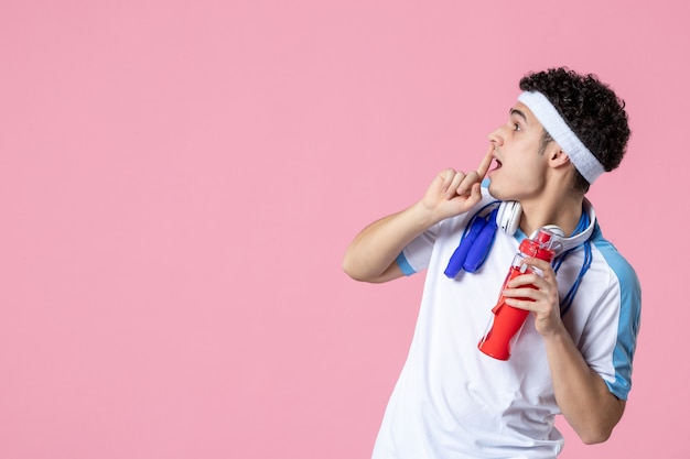 Vue de face de l'athlète masculin en vêtements de sport avec une bouteille d'eau