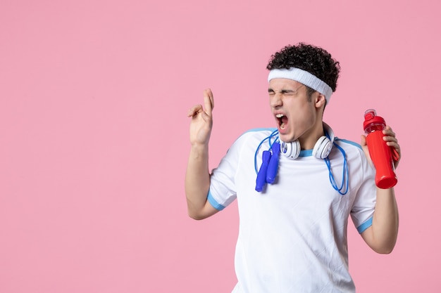 Vue de face de l'athlète masculin en vêtements de sport avec une bouteille d'eau