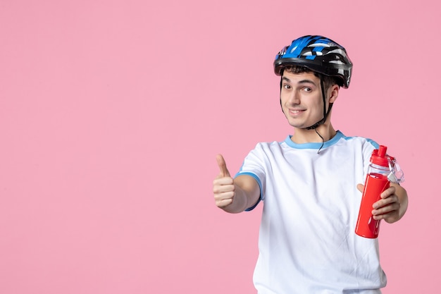 Vue de face de l'athlète masculin en vêtements de sport avec casque et bouteille d'eau