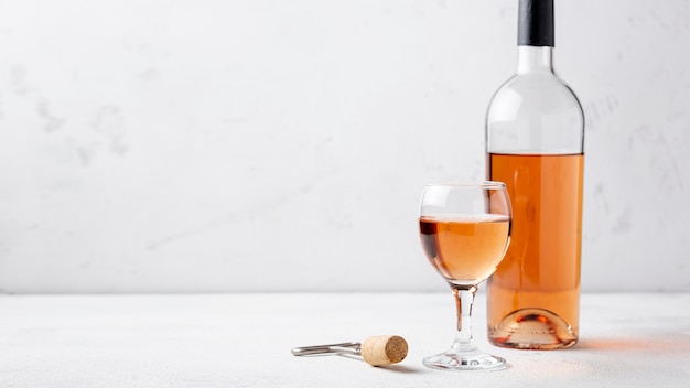 Vue de face bouteille de vin rose et verre