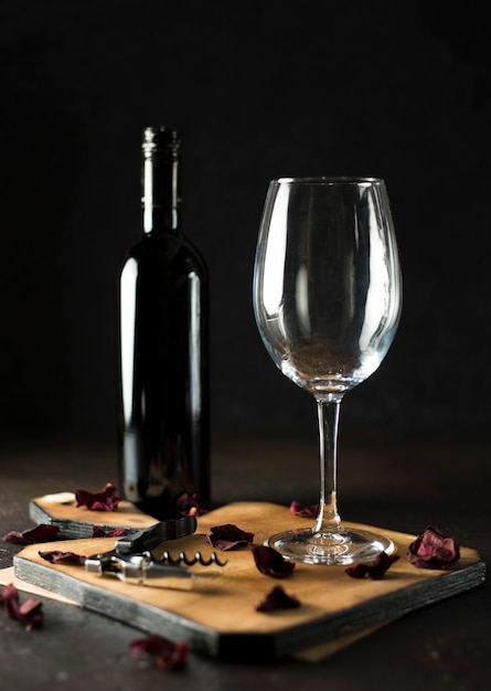Vue de face bouteille de vin rouge et un verre de vide sur le bois