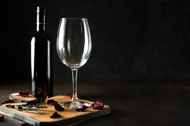 Vue de face bouteille de vin rouge et un verre de vide sur le bois