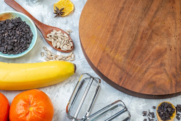 vue de face bureau en bois marron avec fruits oeufs céréales crues et graines sur fond blanc pâte à tarte graine fruits couleur cors cuire gâteau lait