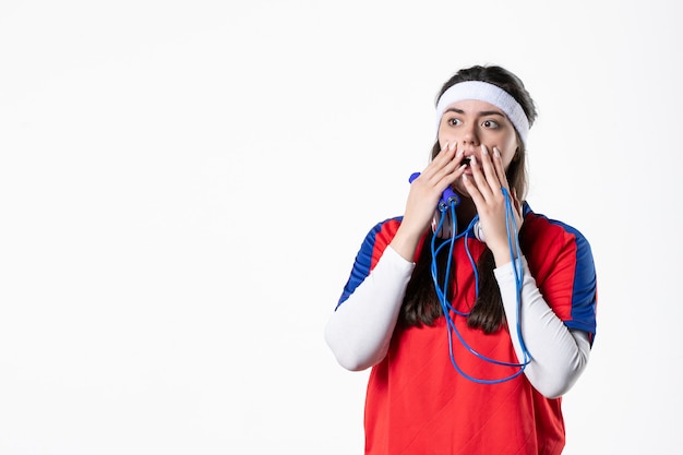 Vue de face choquée jeune femme en vêtements de sport avec des cordes à sauter