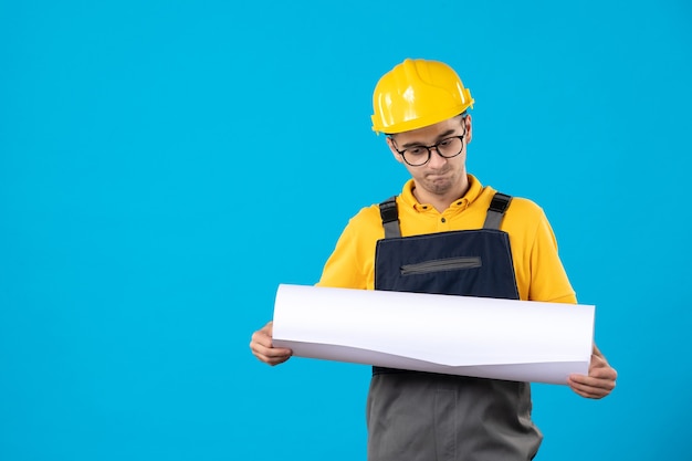 Vue de face constructeur masculin en plan de lecture uniforme jaune sur bleu