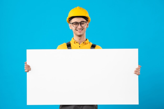 Vue de face constructeur masculin en uniforme jaune avec plan sur bleu