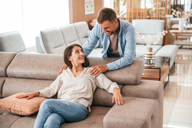 Vue de face Couple choisissant le canapé et le lit dans le magasin