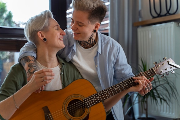 Photo vue de face couple lesbien romantique avec guitare