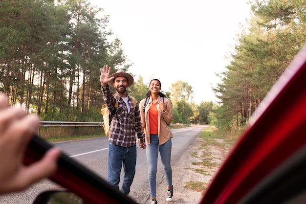 Photo vue de face couple à la recherche de conduire lors d'un voyage