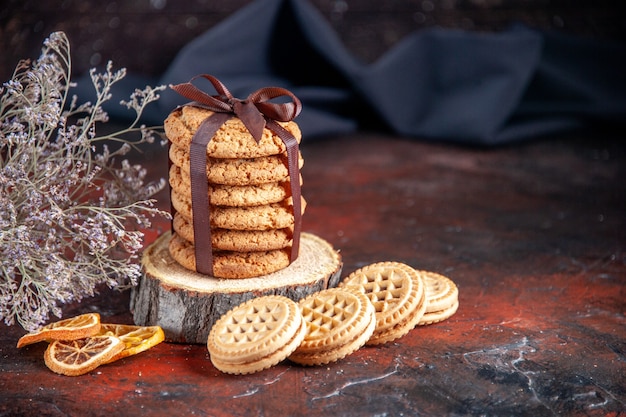 vue de face de délicieux biscuits sucrés attachés avec un arc sur fond sombre gâteau au thé sucré tarte biscuit sucre