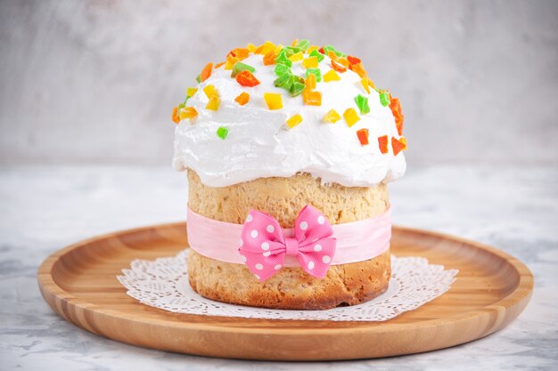 vue de face délicieux gâteau de pâques avec de la crème et des fruits secs sur une surface blanche concept tarte aux desserts couleur colorée printemps