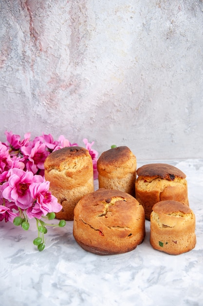 vue de face de délicieux gâteaux de pâques avec des fleurs sur une surface blanche pâques printemps coloré concept tarte dessert couleur