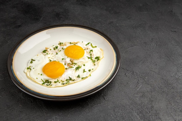 vue de face délicieux œufs brouillés à l'intérieur de la plaque sur fond sombre omelette nourriture petit déjeuner matin déjeuner pain thé repas espace libre
