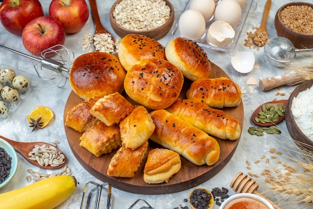 vue de face délicieux petits pains avec pâtisseries céréales et œufs sur fond blanc pâte tarte aux fruits cuire gâteau lait pâtisserie cuire