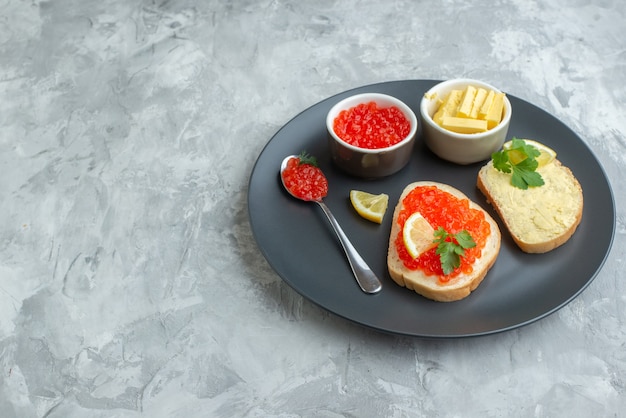 vue de face de délicieux sandwichs au caviar à l'intérieur de la plaque avec du fromage sur une surface blanche collation dîner poisson repas plat pain toast petit déjeuner