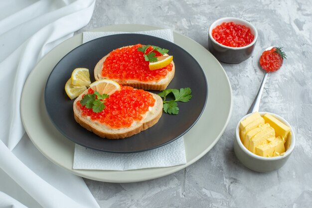 vue de face de délicieux sandwichs au caviar à l'intérieur de la plaque sur une surface blanche collation pain petit déjeuner dîner poisson nourriture toast repas