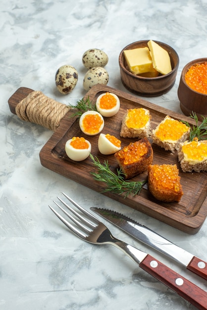 vue de face délicieux sandwichs au caviar et œufs durs sur une planche à découper surface blanche petit déjeuner horizontal repas poisson déjeuner nourriture