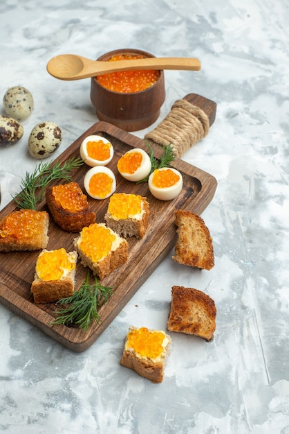 vue de face de délicieux sandwichs au caviar avec des œufs durs sur une planche à découper surface blanche poisson déjeuner nourriture pain grillé horizontal petit-déjeuner de fruits de mer