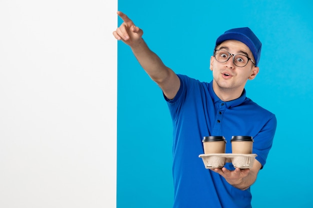 Vue de face du courrier masculin en uniforme bleu avec du café sur le bleu