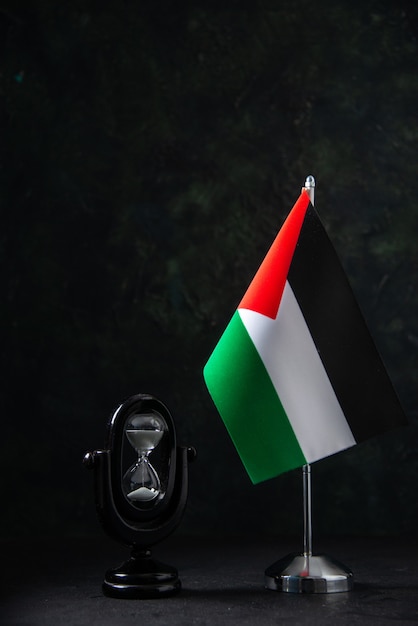 Vue de face du drapeau de la Palestine avec sablier sur fond noir