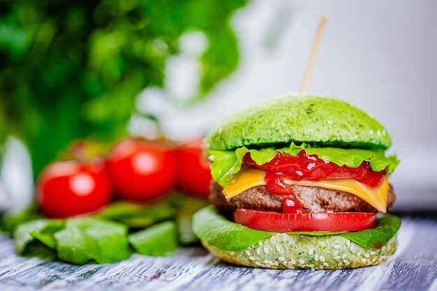 Photo vue de face du hamburger vert avec des légumes frais de viande artificielle sur une table en bois nourriture végétarienne
