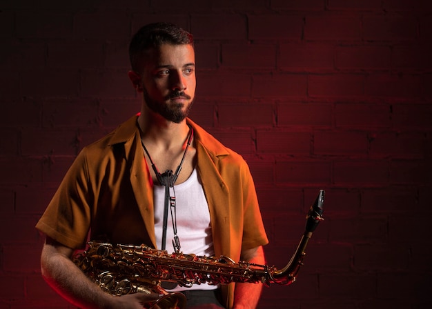 Photo vue de face du musicien tenant un saxophone