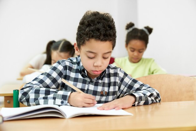 Vue De Face Du Petit Garçon En Train De Faire Un Test à L'école