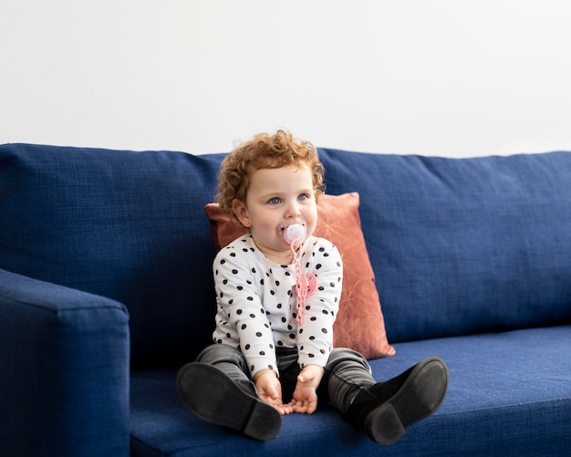 Vue de face de l'enfant assis sur le canapé