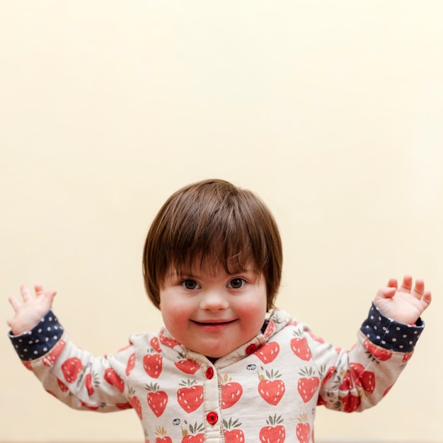 Photo vue de face d'un enfant souriant atteint du syndrome de down