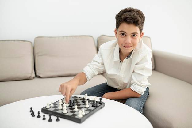 Photo vue de face enfant souriant jouant aux échecs