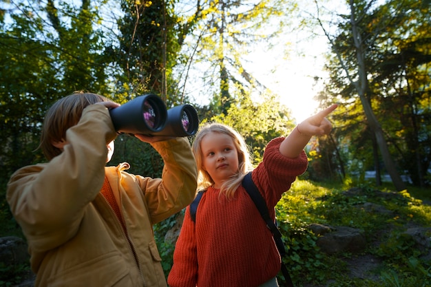 Vue de face des enfants explorant la nature ensemble