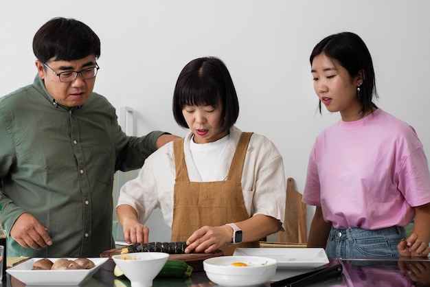 Vue de face famille asiatique avec une cuisine délicieuse