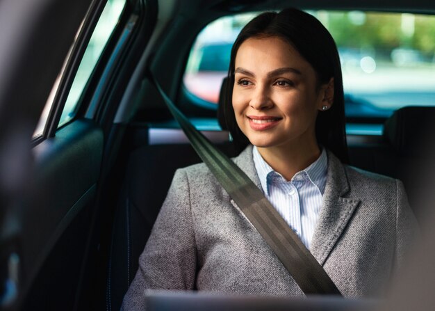 Vue de face de la femme d'affaires smiley dans la voiture