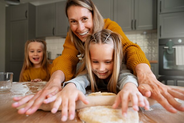 Vue de face femme aidant les filles à cuisiner