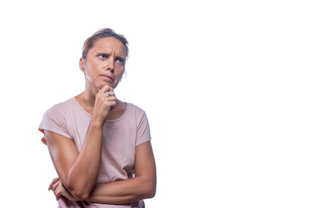 Vue de face d'une femme aux yeux verts réfléchie et concernée sur fond blanc avec espace de copie.